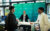 Joachim Schulze und Tim Rieth erklären einem Besucher am DiReX-Stand auf dem ITCS 2026 das Spiel Krisopolis, das im Vordergrund sichtbar ist.